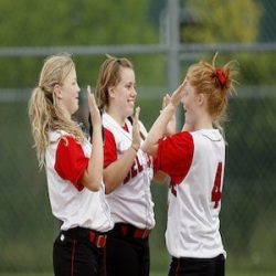three teenage girls giving high fives at a sporting event they are playing in