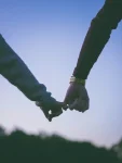 Two hands holding each other gently.