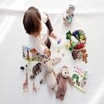 infant sitting on the floor looking at toys